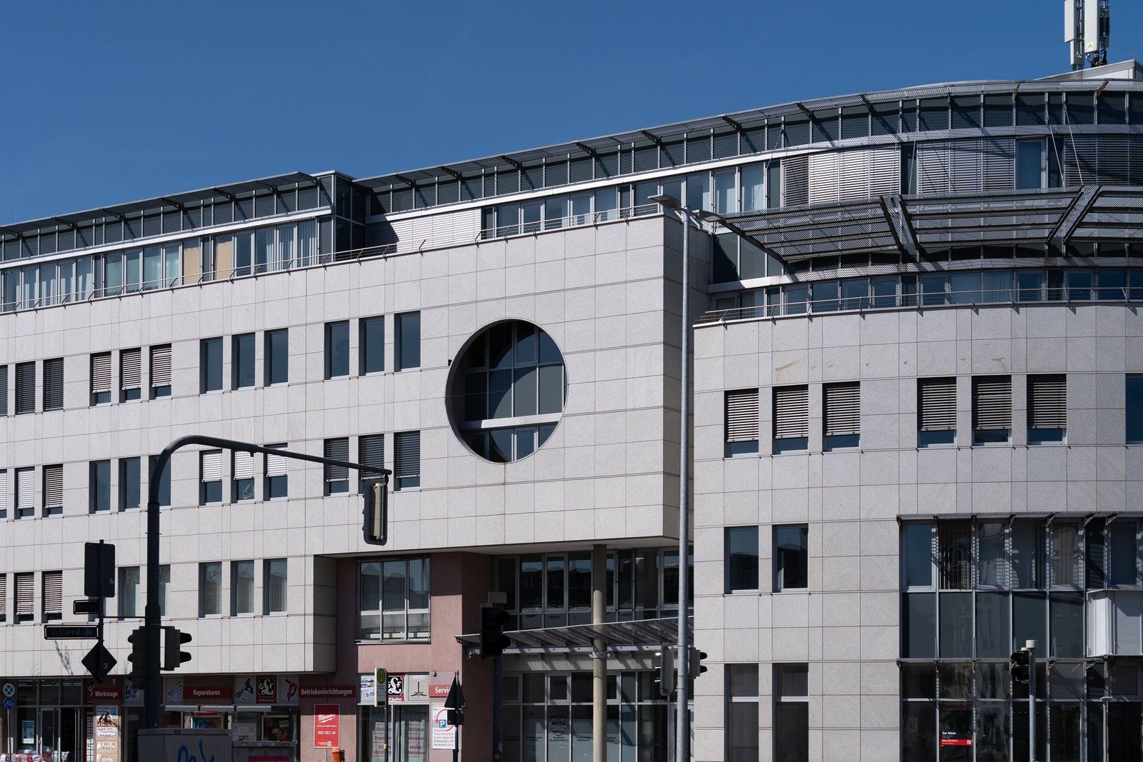 Bürogebäude mit heller Fassade und rundem Fenster