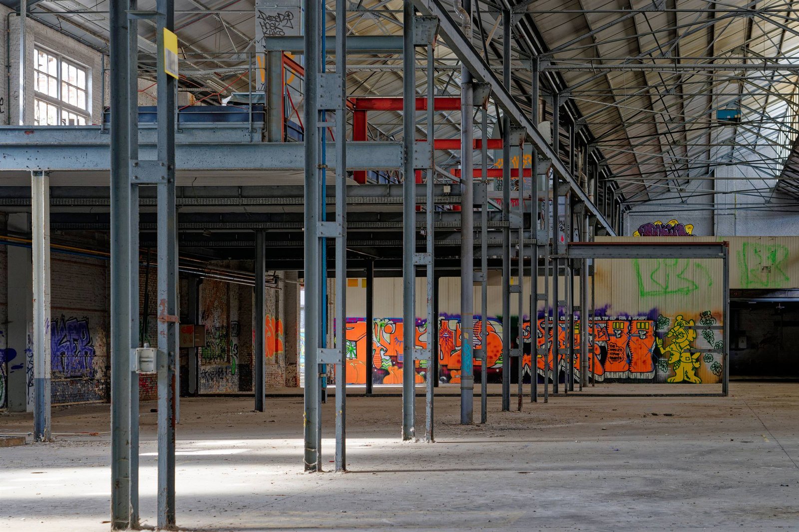 Leere Industriehalle mit Stahlstützen und Oberlichtern