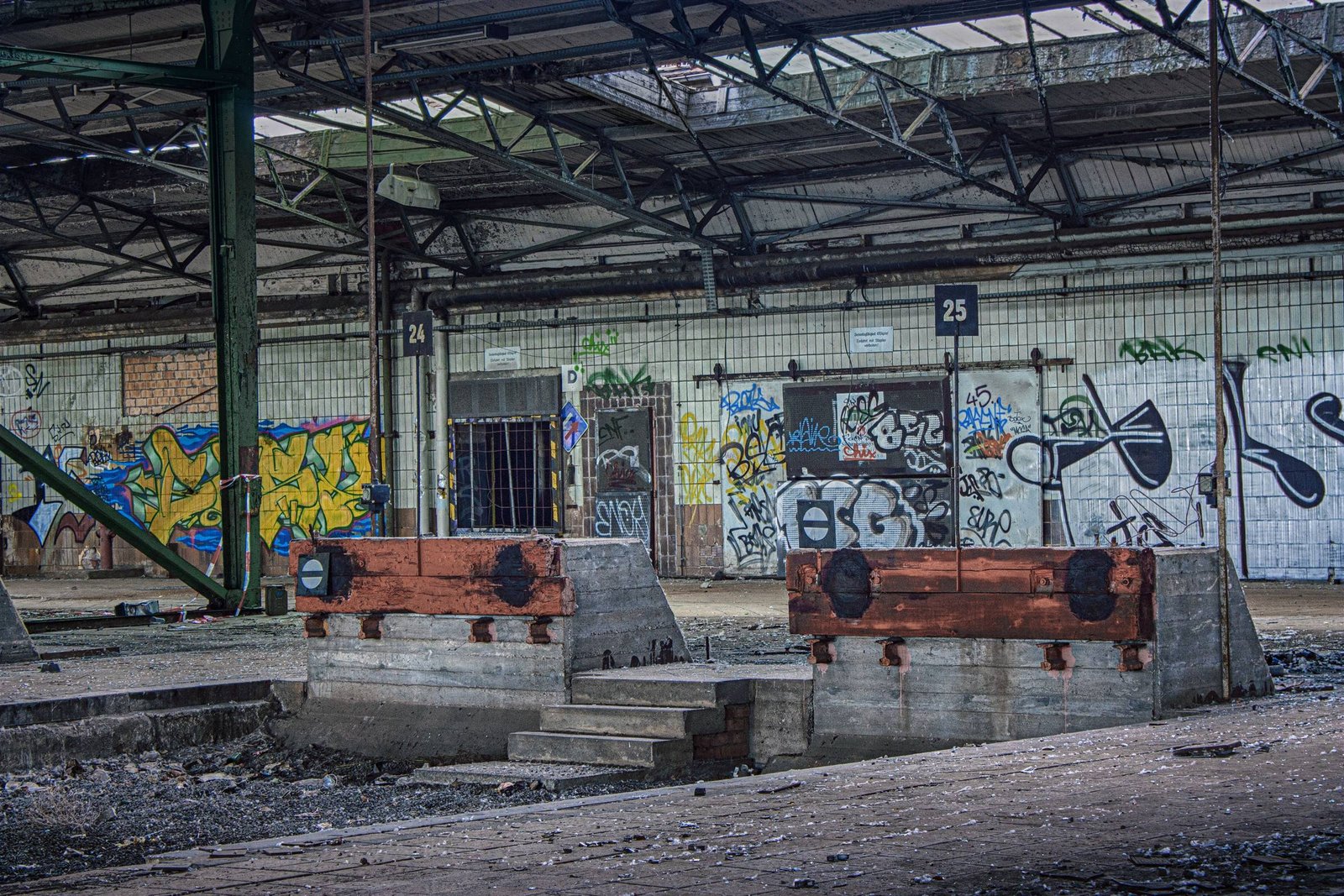 Leerstehende Halle mit Graffiti und alten Prellböcken