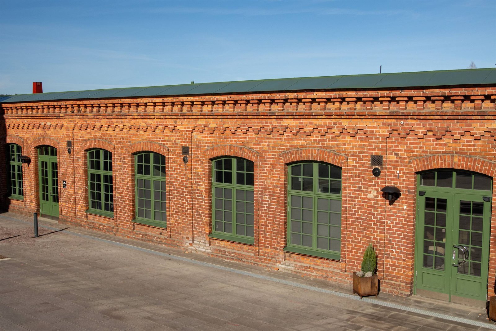 Backsteingebäude mit grünen Sprossenfenstern