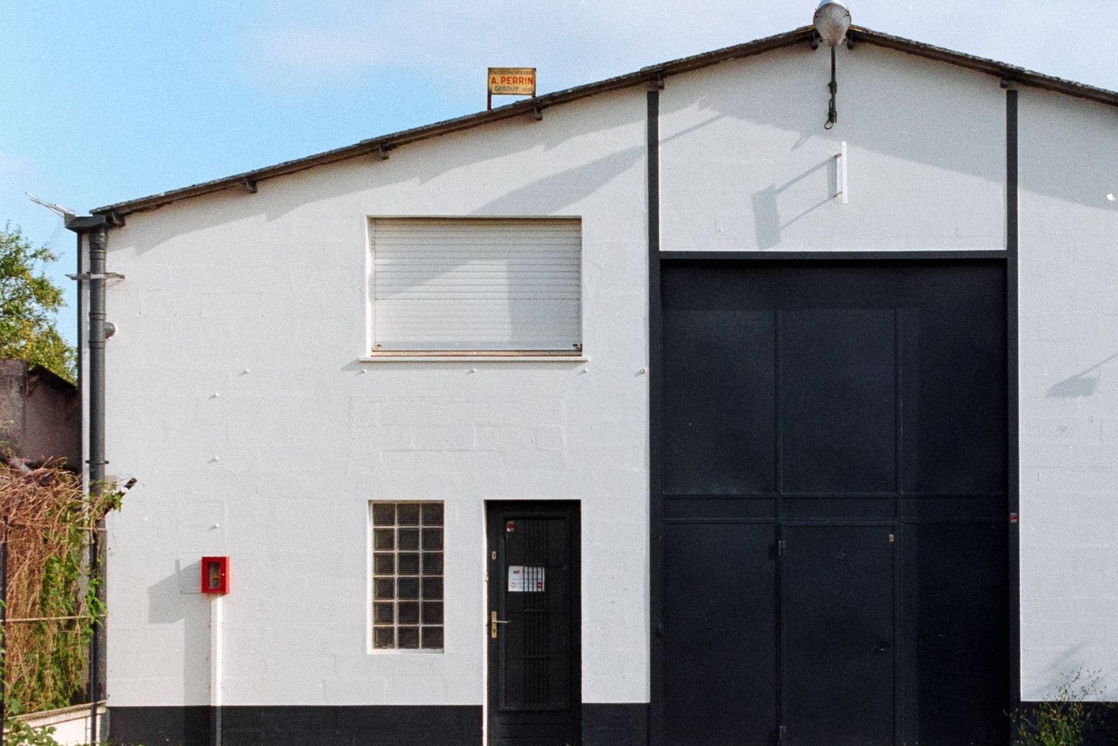 Weiße Halle mit schwarzem Rolltor